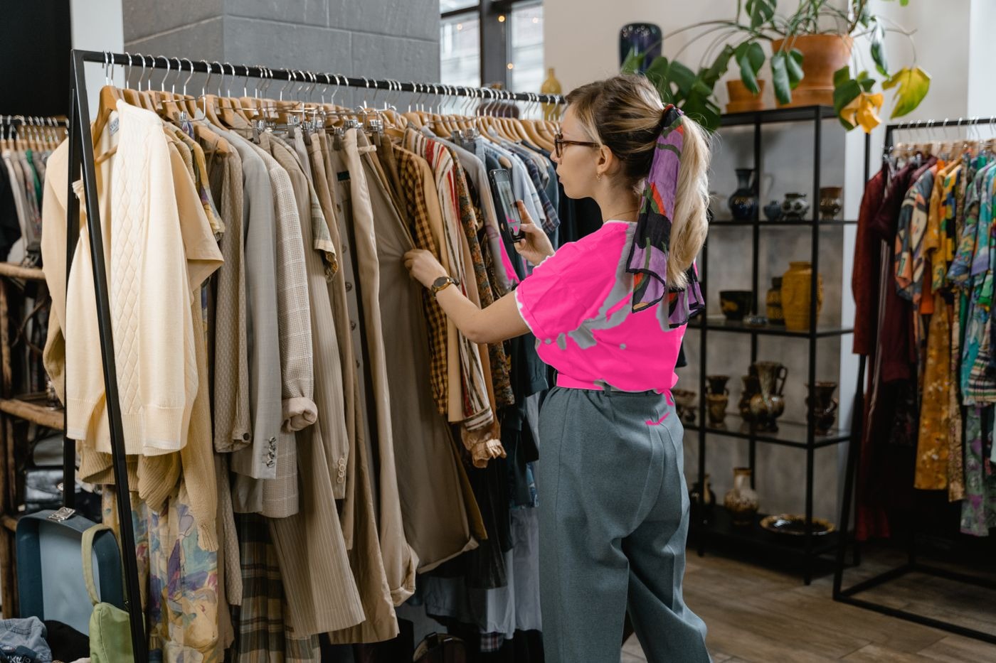 Retail associate photographing merchandise on the clothing store floor